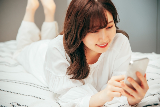 笑顔でスマホを触る女性