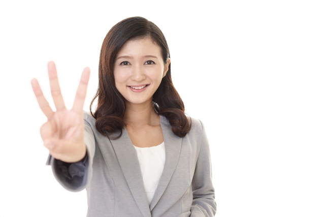 笑顔で3を示す女性